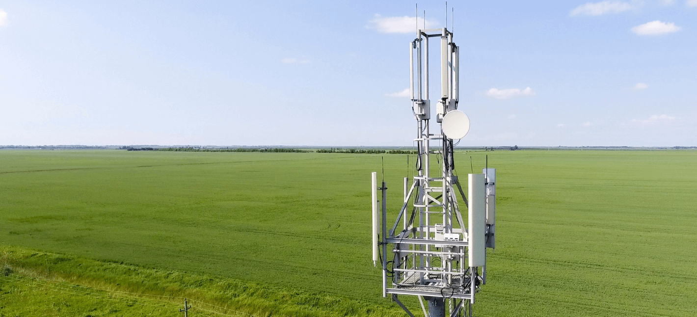 on the image you can see a cellular IoT tower with the background of the green field and blue sky